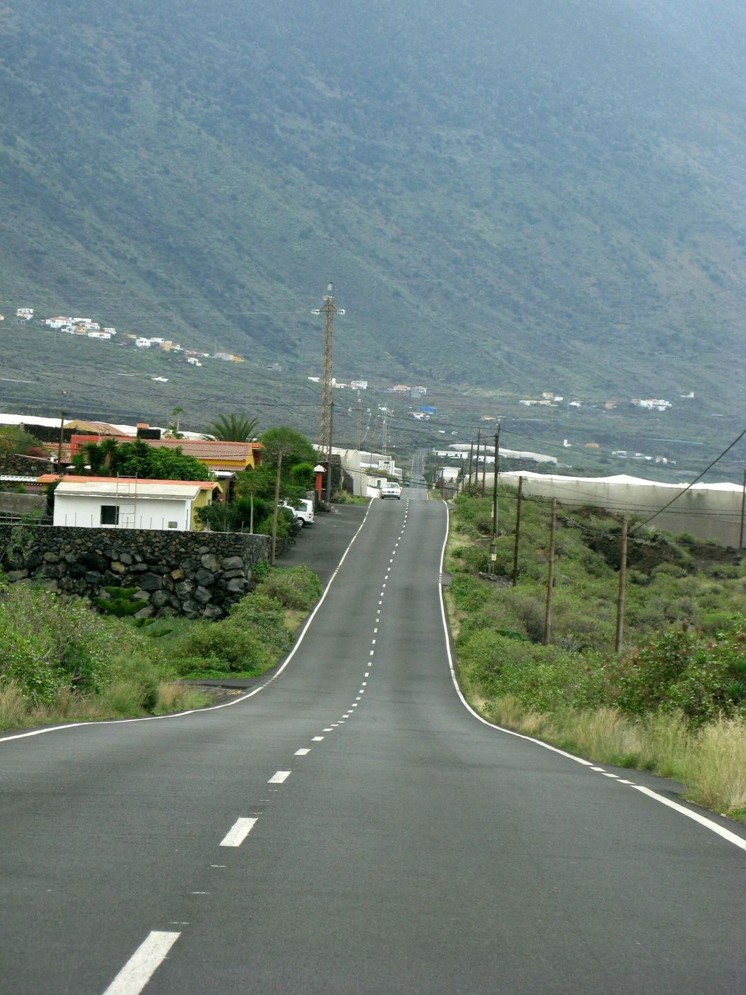 A road with no traffic on it and mountains in the background.