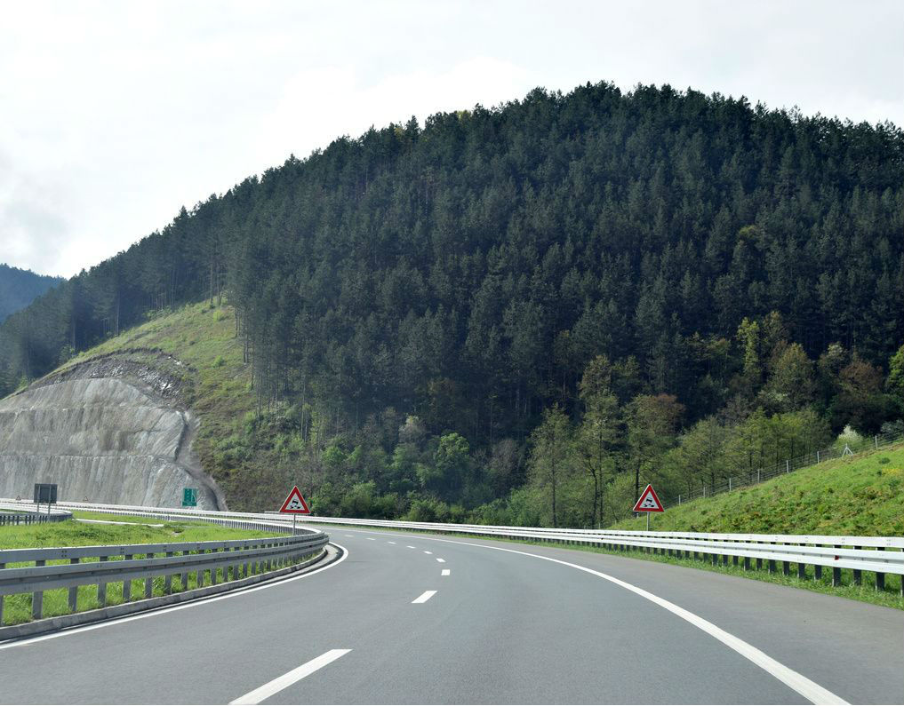 A road with trees and hills in the background